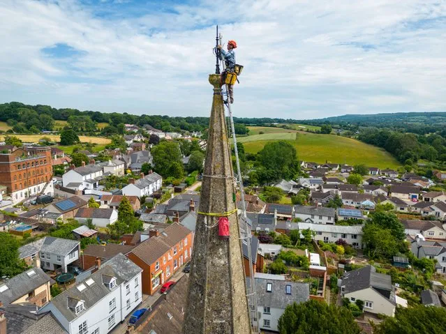 Arthur Needham from Vitruvius Building Conservation paints the lightning conductor on the steeple as part of restoration work at the top of St Mary’s Church, on June 23, 2022 in Uffculme, United Kingdom. (Photo by Finnbarr Webster/Getty Images)