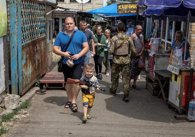 A boy carries a toy gun, amid Russia's invasion of the country, in Kostyantynivka, Donetsk region, Ukraine, June 25, 2022. (Photo by Marko Djurica/Reuters)