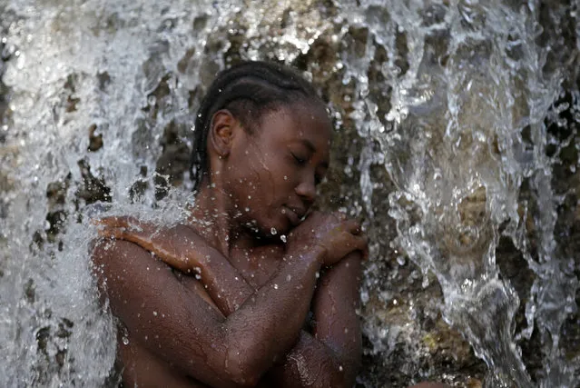 A pilgrim takes a bath during the celebration of the annual pilgrimage to the waterfall in Saut D'Eau, Haiti, July 16, 2016. (Photo by Andres Martinez Casares/Reuters)