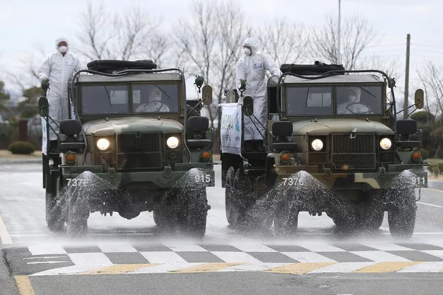 South Korean army trucks spray disinfectant as a precaution against the coronavirus on a street in Ulsan, South Korea, Tuesday, March 3, 2020. China's coronavirus caseload continued to wane Tuesday even as the epidemic took a firmer hold beyond Asia. (Photo by Kim Young-tae/Yonhap via AP Photo)