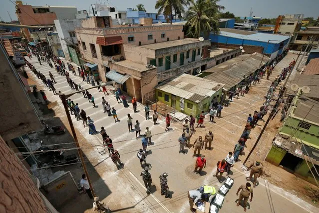 People stand on the lines drawn to maintain safe distance as they wait to receive free food being distributed by Central Reserve Police Force (CRPF) in Chennai, India, April 1, 2020. (Photo by P. Ravikumar/Reuters)