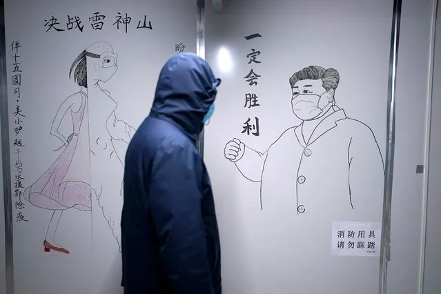 A staff member walks past a sketch of Chinese President Xi Jinping with a face mask on the wall of a closed ward inside the Leishenshan Hospital, a makeshift hospital for treating patients with the coronavirus disease (COVID-19), in Wuhan, Hubei province, China on April 11, 2020. (Photo by Aly Song/Reuters)