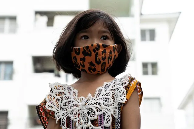 A girl wearing a mask due to the coronavirus disease (COVID-19) outbreak looks on at a community in Bangkok, Thailand, April 10, 2020. (Photo by Athit Perawongmetha/Reuters)