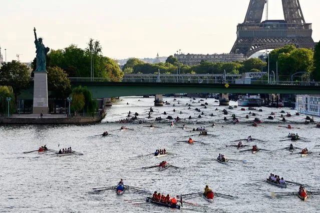Nearly 1000 rowers, in some 230 boats, scull towards the Eiffel Tower as they participate in the 37th edition of “La Traversee de Paris en Aviron” along the River Seine, which flows through the centre of Paris on September 4, 2022. (Photo by Jean-Christophe Verhaegen/AFP Photo)