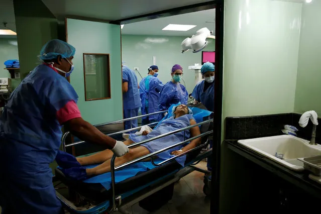 Medical personnel move a woman after her sterilization surgery in the operating room of a hospital in Caracas, Venezuela July 27, 2016. (Photo by Carlos Garcia Rawlins/Reuters)