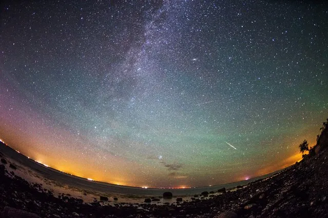 Meteors from the Perseid meteor swarm burn up in the atmosphere as our own galaxy, the Milky Way, is seen in the clear night sky over the German island of Fehmarn, Germany, early 13 August 2015. The Perseid meteor shower occurs every year in summer when the Earth passes through debris and dust of the 109P/Swift-Tuttle comet. (Photo by Daniel Reinhardt/EPA)