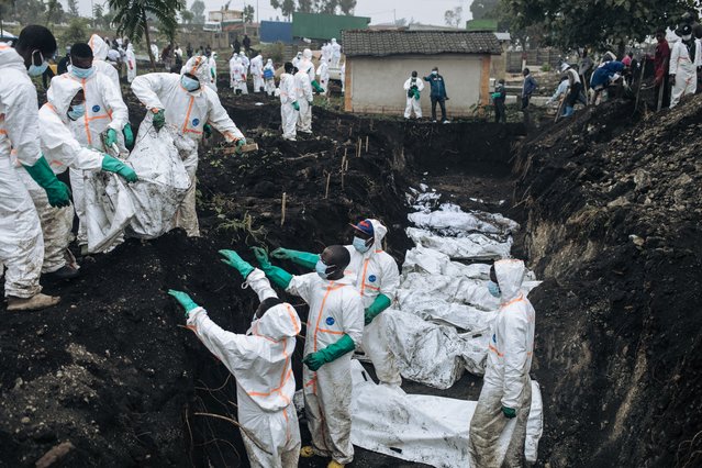 Members of the Congolese Red Cross and Civil Protection bury dozens of victims of the recent clashes in a cemetery in Goma on February 4, 2025. At least 900 people have been killed and more than 2,800 people injured in the recent fighting in Goma, the capital of the Democratic Republic of Congo's North Kivu province, the UN said on Monday. Rwandan-backed armed group M23 has seized Goma, the biggest city in the country's east, and is advancing south as volunteers and the struggling Congolese army attempt to beat them back. (Photo by Alexis Huguet/AFP Photo)