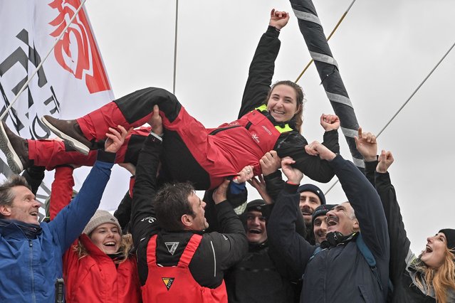 French skipper Violette Dorange (up) celebrates with relatives on her Imoca monohull Devenir after placing 25th in the 10th edition of the Vendee Globe around the world monohull solo sailing race in Les Sables-d'Olonne, western France, on February 9, 2025. (Photo by Sebastien Salom-Gomis/AFP Photo)