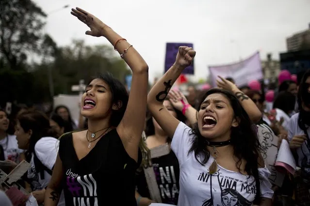 Women chant slogans against the justice system during a march against domestic violence in Lima, Peru, Saturday, August 13, 2016. Almost a hundred women are killed every year in domestic violence cases according to local authorities. (Photo by Rodrigo Abd/AP Photo)