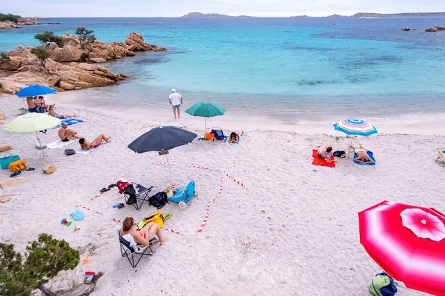 Some tourists on a beach in Sardinia try to respect the rules of social distancing by using a white and red ribbon to mark their space on the beach on the first weekend of phase 3 after the lockdown due to Covid-19 on June 07, 2020 in Porto Cervo, Sardegna, Italy. Many Italian businesses have been allowed to reopen, after more than two months of a nationwide lockdown meant to curb the spread of Covid-19. (Photo by Emanuele Perrone/Getty Images)