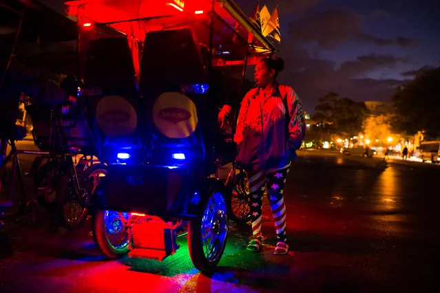 As the sun rises over Old Havana on January 31, 2015, Odalys Monroy, 49, stands in a pair of American Flag pants as she talks to a bici taxi driver on the way to work. (Photo by Sarah L. Voisin/The Washington Post)