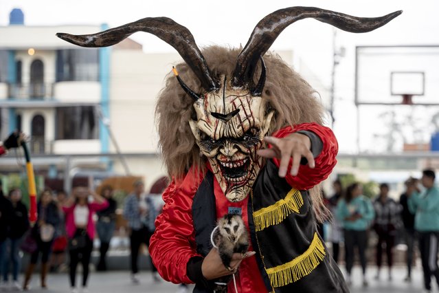 Wearing a devil mask, a reveler dances through the streets during the “Diablada de Pillaro”, or the Devils of Pillaro festival, to send out the old year and bring in the new, in the Andean town of Pillaro, Ecuador, Monday, January 1, 2024. (Photo by Carlos Noriega/AP Photo)