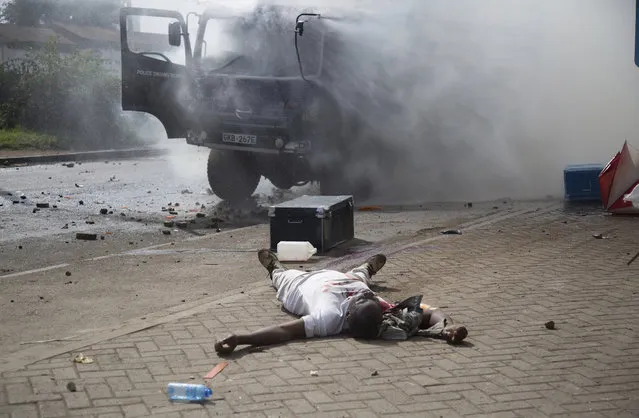 A supporter of Kenyan opposition National Super Alliance (NASA) coalition lies on the road after being shot dead by police in Nairobi, Kenya, Friday, November 17, 2017. (Photo by Brian Inganga/AP Photo)