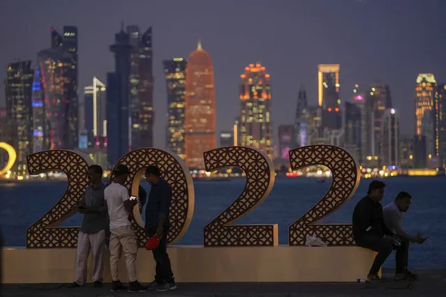 With the city skyline in the background, people pose for a photograph at the corniche in Doha, Qatar, Thursday, November 17, 2022. Final preparations are being made for the soccer World Cup which starts on Nov. 20 when Qatar face Ecuador. (Photo by Hassan Ammar/AP Photo)