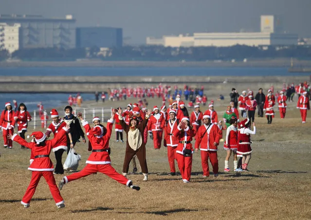 Runners in Santa Claus costumes take part in the Christmas charity event “Tokyo Santa Run” at the Makuhari Seaside Park in Chiba on December 23, 2017. About 1,000 people attended the charity event to provide Christmas presents for children fighting disease. (Photo by Toshifumi Kitamura/AFP Photo)