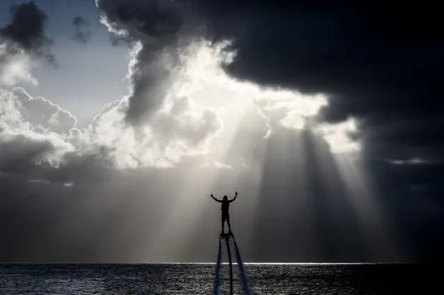 A man practices using a fly board on the sea on November 17, 2022 in Le Gosier, off the French overseas island of Guadeloupe. (Photo by Loic Venance/AFP Photo)