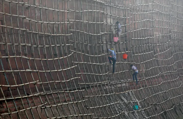 Workers climb scaffolding to clean the walls of the historic Red Fort in the old quarters of Delhi, India December 27, 2017. (Photo by Saumya Khandelwal/Reuters)