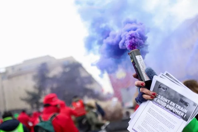 A person holding a smoke grenade takes part in a demonstration against the rising cost of living, in Brussels, Belgium on December 16, 2022. (Photo by Johanna Geron/Reuters)