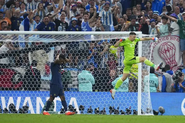 Argentina's goalkeeper Emiliano Martinez celebrates blocking a shot from France's Kingsley Coman in a penalty shootout during the World Cup final soccer match between Argentina and France at the Lusail Stadium in Lusail, Qatar, Sunday, December 18, 2022. (Photo by Natacha Pisarenko/AP Photo)