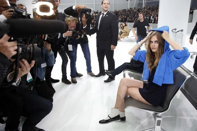 Model Cara Delevingne is surrounded by photographers as she arrives to attend German designer Karl Lagerfeld's Spring/Summer 2016 women's ready-to-wear collection show for fashion house Chanel at the Grand Palais which is transformed into a Chanel airport during the Fashion Week in Paris, France, October 6, 2015. (Photo by Charles Platiau/Reuters)