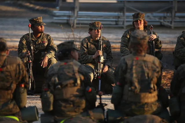 Male and female Marines prepare to head out on a 15-kilometer night march with male and female Marines during Marine Combat Training (MCT) on February 21, 2013 at Camp Lejeune, North Carolina.  Since 1988 all non-infantry enlisted male Marines have been required to complete 29 days of basic combat skills training at MCT after graduating from boot camp. MCT has been required for all enlisted female Marines since 1997. About six percent of enlisted Marines are female.  (Photo by Scott Olson)