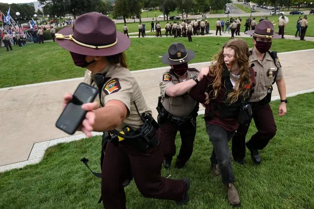 A counter protester is detained for interference of the use of public property during a rally in St. Paul, Minnesota, U.S., September 12, 2020. (Photo by Nicholas Pfosi/Reuters)