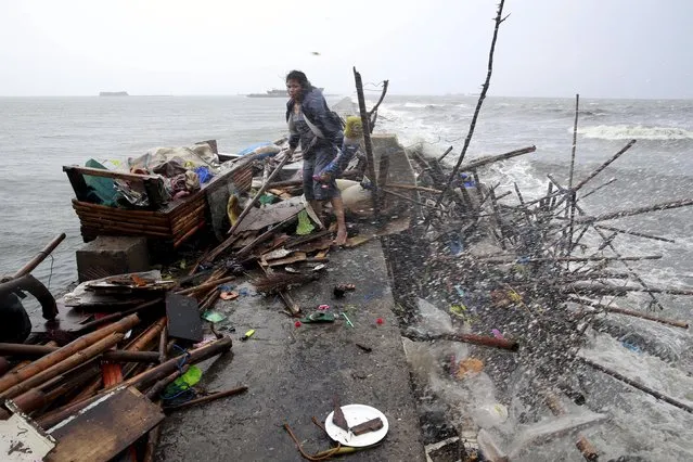 Liza Taroyo, living along the coast of Manila Bay searches for salvageable items after her house was damaged  by strong winds brought by typhoon Koppu on October 18, 2015. (Photo by Romeo Ranoco/Reuters)