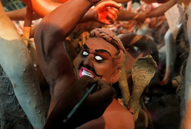 An artisan paints an idol of mythological demon Mahisasura ahead of the Durga Puja festival, in Allahabad, India, September 25, 2016. (Photo by Jitendra Prakash/Reuters)