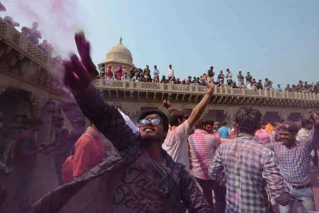 Indian Hindu devotees celebrate Holi, the spring festival of colours, during a traditional gathering at the temple of  Nandgaon village in Uttar Pradesh state on February 25, 2018. Holi is observed in India at the end of the winter season on the last full moon of the lunar month. (Photo by Dominique Faget/AFP Photo)