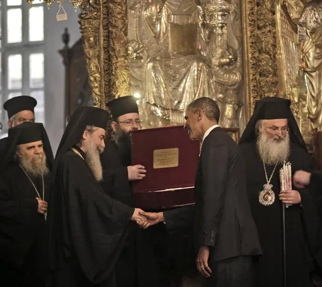 President Barack Obama is presented a gift by Greek Orthodox Patriarch Theophilos III, left, Friday, March 22, 2013, at the Church of the Nativity during his visit to the West Bank city of Bethlehem. (Photo by Pablo Martinez Monsivais/AP Photo)