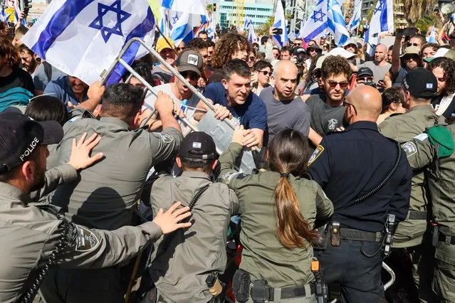 Protesters scuffle with members of Israeli security forces during a demonstration against the government's controversial justice reform bill in Tel Aviv on March 1, 2023. (Photo by Jack Guez/AFP Photo)