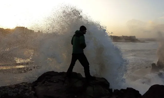 A man watches as waves crash into a cliff at Portstewart in northern Ireland December 10, 2014. Up to 17,000 residents in the west of Scotland were left without power on Wednesday morning as a “weather bomb” of wet and windy conditions battered parts of Britain with gusts expected to reach up to 80 miles per hour (130 km/h). (Photo by Cathal McNaughton/Reuters)