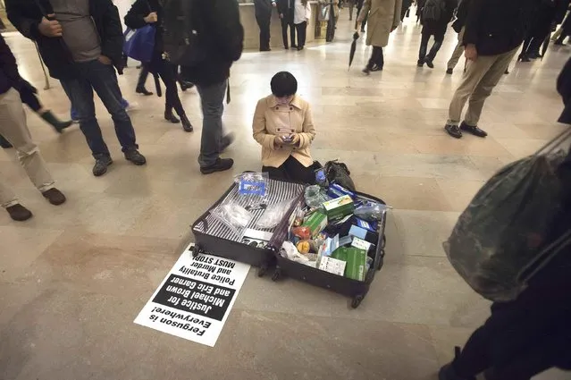 A woman sits on the floor with a bag full of supplies for demonstrators as they protest against the New York City grand jury decision to not indict in the death of Eric Garner, at Grand Central Terminal in the Manhattan borough of New York, December 9, 2014. The death in New York of Garner, a 43-year-old father of six, and the police shooting in Ferguson, Missouri, of Michael Brown, have highlighted strained relations between police and black Americans and rekindled a national debate over race relations. (Photo by Carlo Allegri/Reuters)