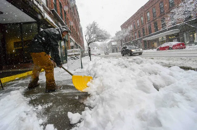 Jeremiah Ferland, of Brattleboro, Vt., shovels some of the sidewalks in downtown Brattleboro, Vt., as the snow falls on Tuesday, March 14, 2023. (Photo by Kristopher Radder/The Brattleboro Reformer via AP Photo)