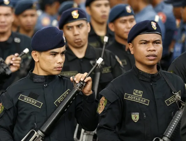 Officers of the Philippine National Police force show the taped muzzle of their guns at a police camp in Taguig City, south of Manila, Philippines, 22 December 2014. (Photo by Francis R. Malasig/EPA)