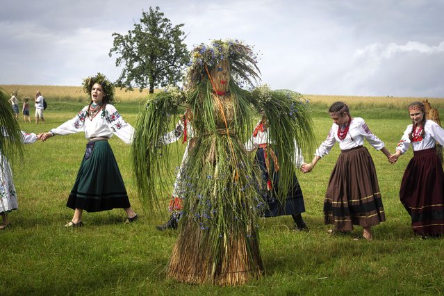 Ukrainian young women dressed in traditional clothing dance in circle at a traditional Midsummer Night celebration near capital Kyiv, Ukraine, Sunday, June 23, 2024. The age-old pagan festival is still celebrated in Ukraine amid the third year of Russia-Ukraine war. (Photo by Efrem Lukatsky/AP Photo)