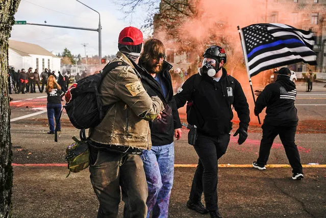 Demonstrators aid a Trump supporter who was beaten by counter-protesters during political clashes on December 12, 2020 in Olympia, Washington. Far-right and far-left groups squared off near the Washington State Capitol following violent clashes over the previous weekend. (Photo by David Ryder/Getty Images)