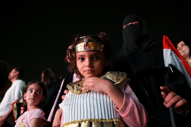A girl wears a costume as people gather to watch the official opening ceremony of the Grand Egyptian Museum (GEM) on a big screen in the downtown area near Tahrir Square, in front of Abdeen Palace Museum, in Cairo, Egypt, on November 1, 2025. (Photo by Mohamed Abd El Ghany/Reuters)