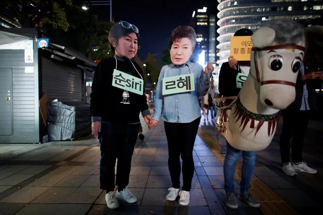 Protesters wearing cut-out of South Korean President Park Geun-hye (C) and Choi Soon-sil attend a protest denouncing President Park Geun-hye over a recent influence-peddling scandal in central Seoul, South Korea, October 27, 2016. (Photo by Kim Hong-Ji/Reuters)