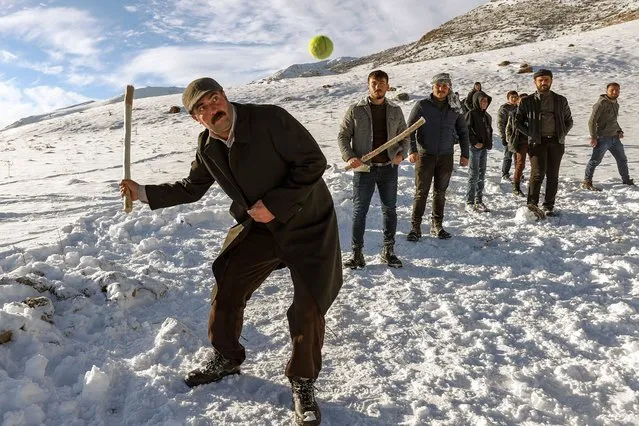 Men play baseball with their own rules called in the snow covered area in Gevas disrtict of Van province, Turkey on January 23, 2021. The game called “topa garane” wich is played in two sets of 6 players in a snow-covered area, with a stick and a ball made of horsehair, is one of the favorite games of the local people. (Photo by Ozkan Bilgin/Anadolu Agency via Getty Images)