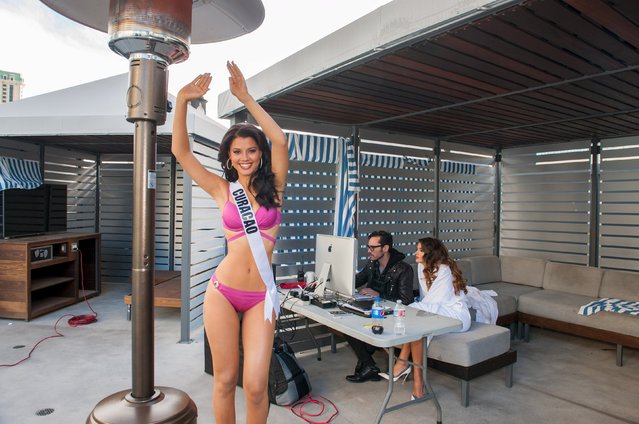Miss Curacao 2015 Kanisha Sluis warms up during her photoshoot in Yamamay swimwear while Miss Georgia 2015 Janet Kerdikoshvili reviews her photos with Chief Photo Editor Frank Szelwach at Planet Hollywood Resort & Casino, in Las Vegas, Nevada, in this handout received by Reuters on December 4, 2015. (Photo by Matt Petit/Reuters/The Miss Universe Organization)
