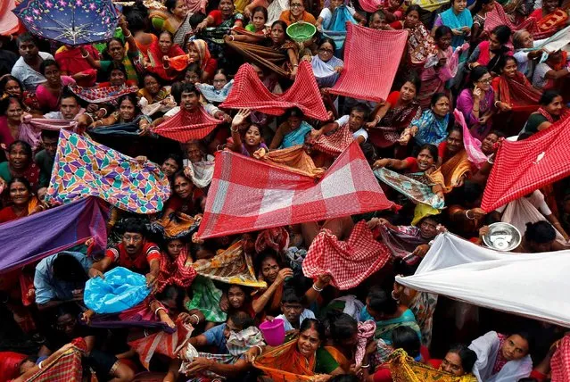 Hindu devotees hold up scarves to receive rice as offerings being distributed by the temple authority on the occasion of the Annakut festival in Kolkata, India October 31, 2016. (Photo by Rupak De Chowdhuri/Reuters)