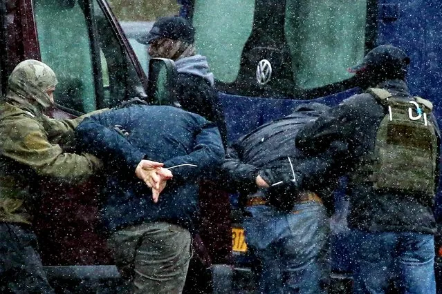 Law enforcement officers detain two men as opposition supporters rally to protest against police violence and the Belarus presidential election results in Minsk, on November 29, 2020. Opposition protesters in Belarus took to the streets of capital Minsk on November 29 in the latest of three months of demonstrations against the re-election of the president. (Photo by AFP Photo/Stringer)