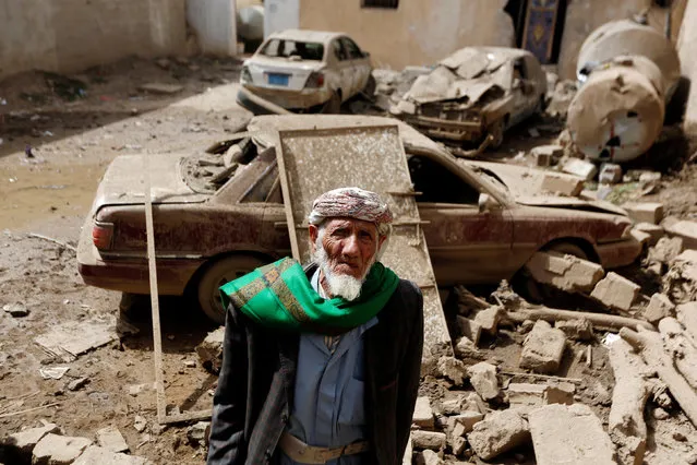 A man stands next to cars damaged by an air strike in Amran, Yemen on June 25, 2018. (Photo by Khaled Abdullah/Reuters)