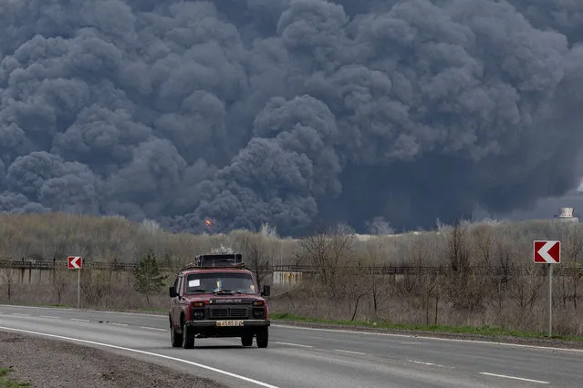 A car passes the Lysychansk Oil Refinery after if was hit by a missile at Lysychansk, Luhansk region, Ukraine, April 16, 2022. (Photo by Marko Djurica/Reuters)