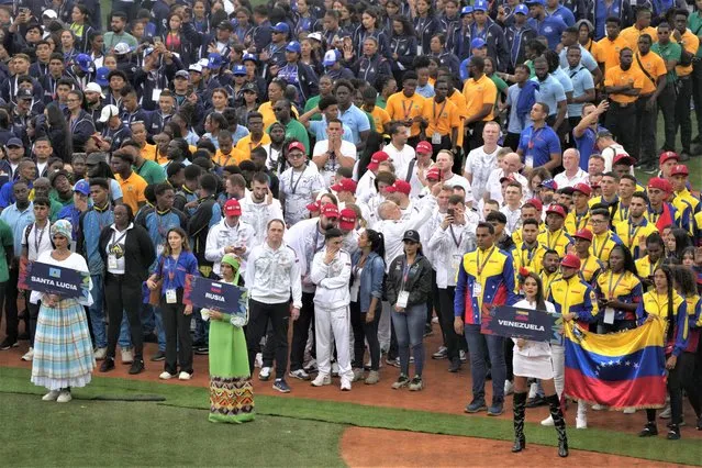 Athletes from Santa Lucia, from left, Russia, and Venezuela, take part in the Alba Games' opening ceremony at the baseball stadium in La Guaira, Venezuela, Friday, April 21, 2023. (Photo by Ariana Cubillos/AP Photo)