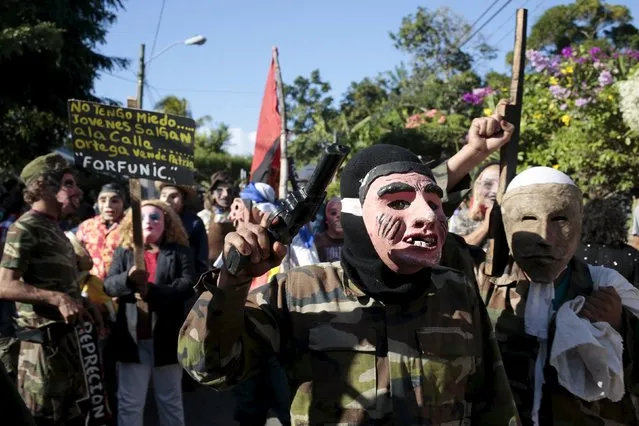 Men wearing masks and dressed as military members take part in a festival honouring San Silvestre, in the town of Catarina, Nicaragua January 1, 2016. The placard reads, "I'm not afraid, young people off the streets, Ortega you sell our country", in reference Nicaragua's President Daniel Ortega. (Photo by Oswaldo Rivas/Reuters)