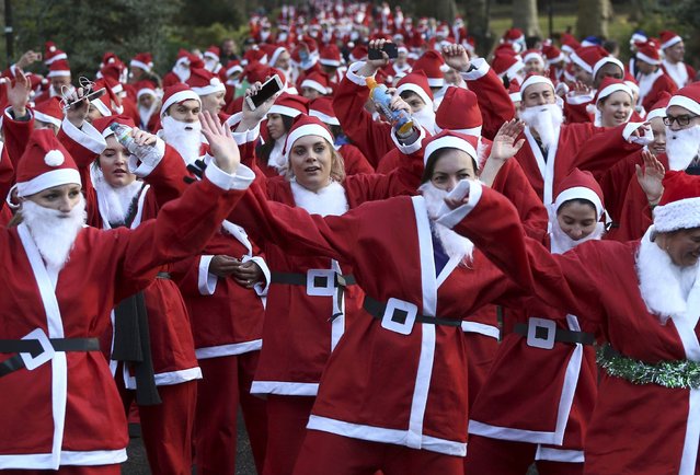 Participants warm up before taking part in a Santa Run at Battersea Park in London, Britain December 3, 2016. (Photo by Neil Hall/Reuters)