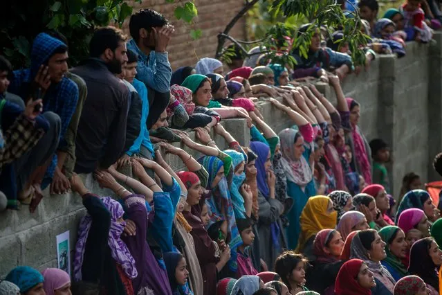 Kashmiri villagers watch the funeral procession of top rebel commander Gulzar Ahmed Paddroo in Aridgeen, about 75 kilometers south of Srinagar, Indian controlled Kashmir, Saturday, September 15, 2018. Indian troops laid a siege around a southern village in Qazigund area overnight on a tip that militants were hiding there, police said. A fierce gunbattle erupted early Saturday, and hours later, five local Kashmiri rebels were killed. (Photo by Dar Yasin/AP Photo)