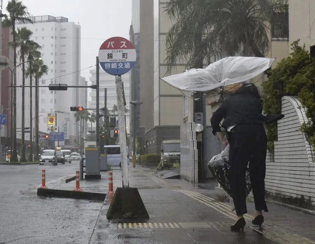 A pedestrian tries to keep an umbrella damaged in a storm in Miyazaki, southern Japan, Tueaday, August 8, 2023. Early Tuesday morning, the storm was centered 350 kilometers (217 miles) south of Kagoshima, a city on the southwestern tip of Japan’s main southern island of Kyushu and southwest of Miyazaki. Khanun produced winds of 108 kph (67 mph) with gusts to 144 kph (89 mph) and was slowly moving north, the Japan Meteorological Agency reported. (Photo by Kyodo News via AP Photo)